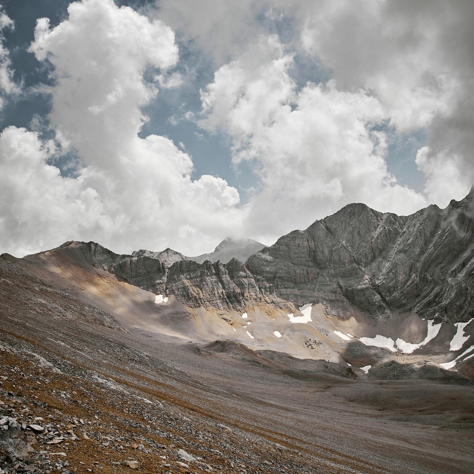 Breathtaking view of a mountain range with dramatic clouds above. Ideal for adventure and landscape enthusiasts.
